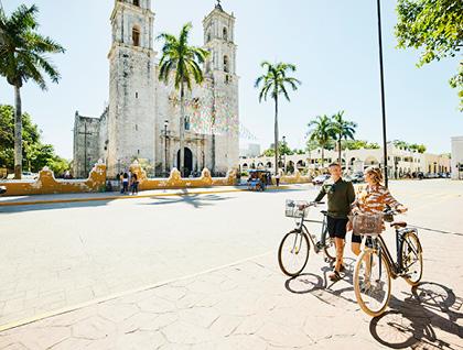 Couple walking their bikes while touring a foreign city