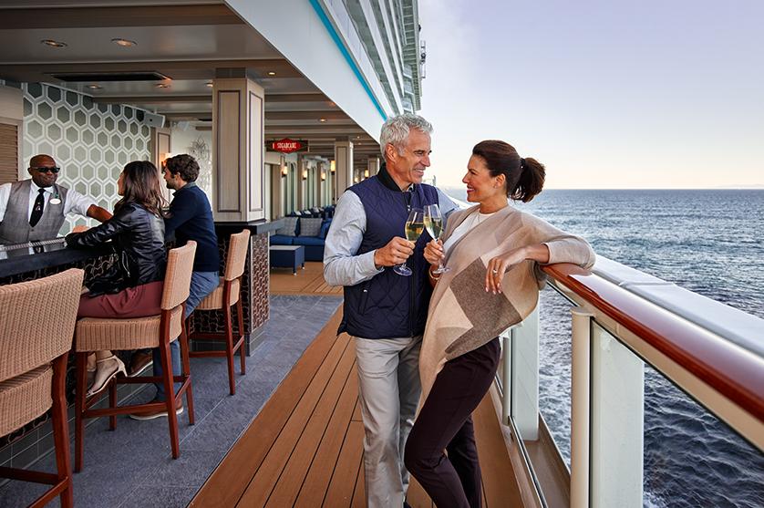 couple enjoying drinks and conversation on board the NCL cruise ship bar